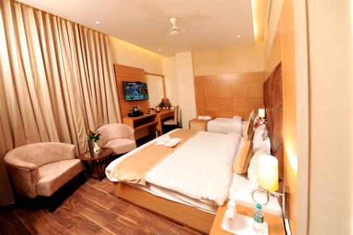 a hotel room with a bed and a chair at The Landmark Amritsar in Amritsar