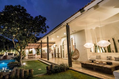 a house with a swimming pool and a yard at La Payesa in Canggu