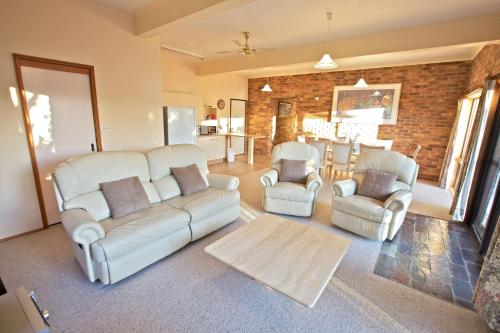 a living room with couches and chairs and a kitchen at Snowy Wilderness in Ingebyra