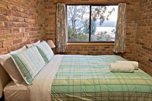 a bedroom with a bed and a brick wall at Snowy Wilderness in Ingebyra