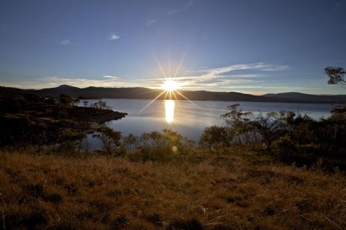 a sun setting over a body of water at Snowy Wilderness in Ingebyra