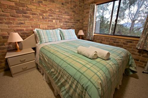 a bedroom with a bed and a brick wall at Snowy Wilderness in Ingebyra
