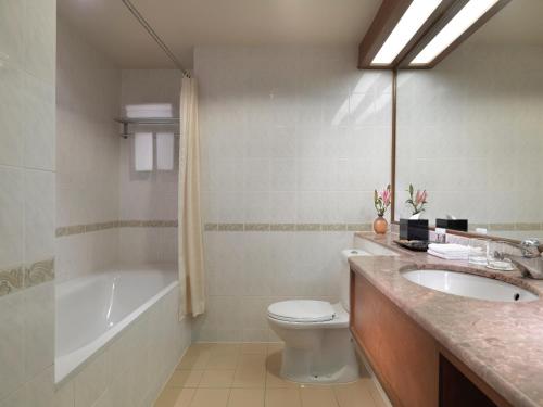 a bathroom with a sink and a toilet and a bath tub at Concorde Hotel Shah Alam in Shah Alam