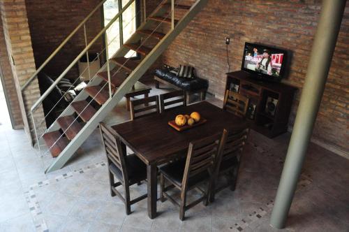 a dining room with a table with chairs and a television at Los Olivos Loft in Rosario