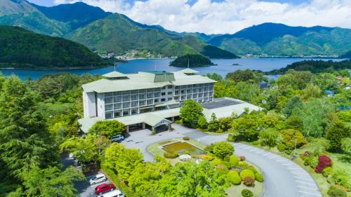 an aerial view of a building with a lake and mountains at Fuji View Hotel in Fujikawaguchiko