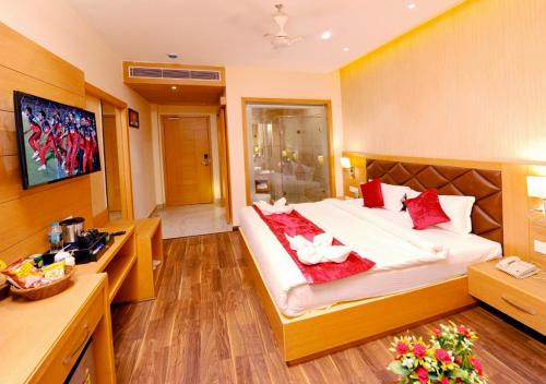 a hotel room with a large bed with red pillows at The Landmark Amritsar in Amritsar