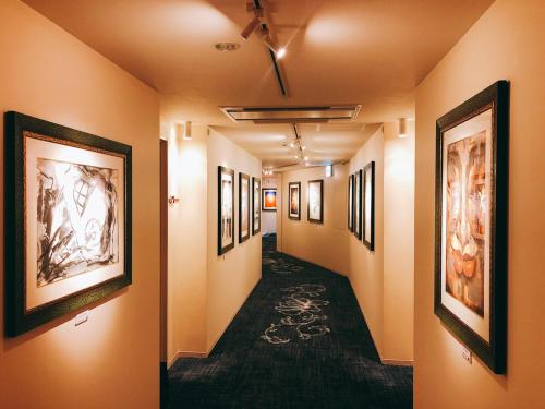 a hallway with paintings on the walls at Hotel Palm Royal Resort Kokusai Street in Naha