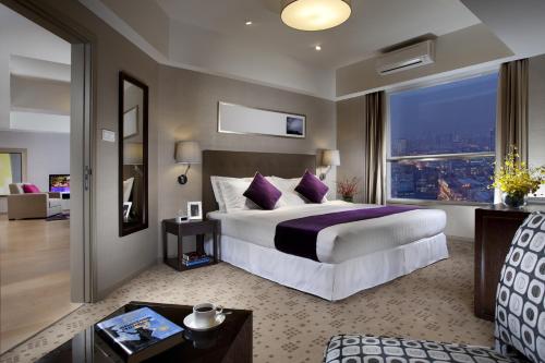 a bedroom with a large bed and a large window at Somerset Heping Shenyang in Shenyang