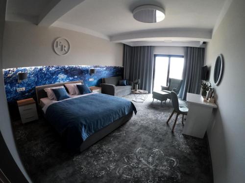 Family Resort Sarbinowo في ساربينوفو: غرفة نوم بسرير ازرق وغرفة معيشة