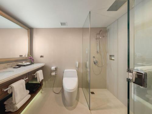 a bathroom with a shower, toilet and sink at Dusit Thani Manila in Manila