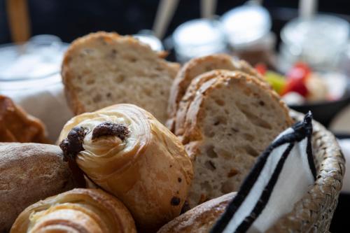 a bunch of different types of bread in a basket at Du Coté de chez Jeanne, Suite in Verviers