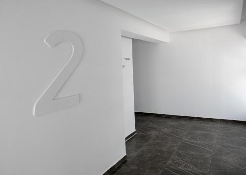 an empty room with a white wall and a tile floor at Kokkinos Boutique Hotel in Protaras