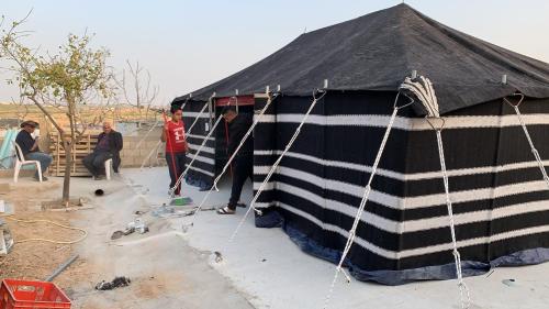 a large black and white tent with people inside at Khan Alsira - חאן אלסרה in Alsira