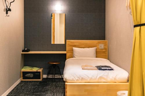 a woman laying on a bed in a room at I-Link Hostel & Cafe Shimanami in Imabari