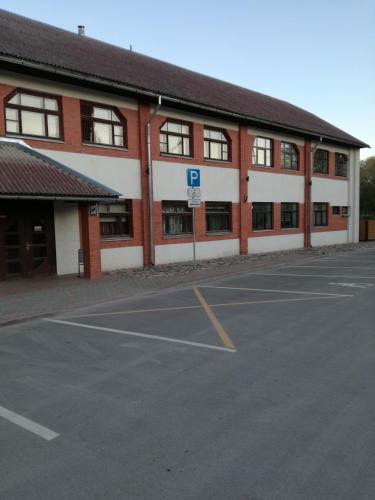 a parking lot in front of a brick building at Brīvdienas in Alūksne