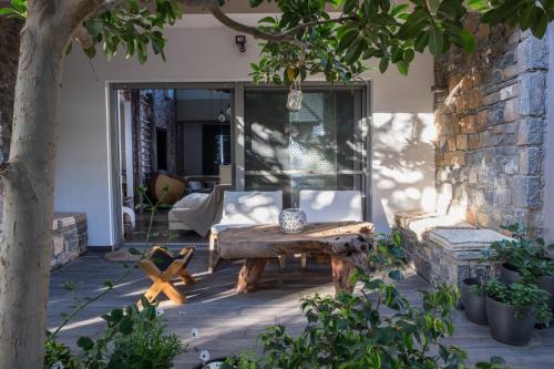 a patio with a wooden bench and a table at Relux Suite in Agios Nikolaos