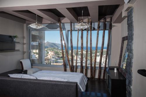 a bedroom with a bed and a large window at Relux Suite in Agios Nikolaos
