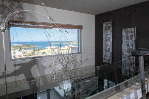 a bathroom with a window with a view of the ocean at Relux Suite in Agios Nikolaos