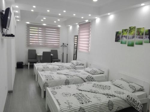 Habitación con 4 camas, mesa y sillas en Apartments Airport Inn, en Dubrave Gornje
