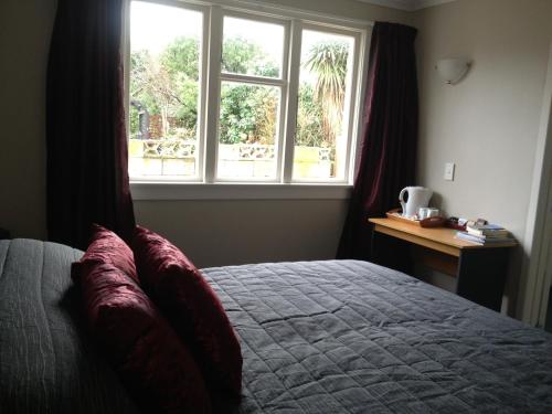 a bedroom with a bed and a window at Lovett Lodge in Invercargill