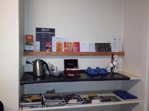 a shelf with books and other items on it at Lovett Lodge in Invercargill