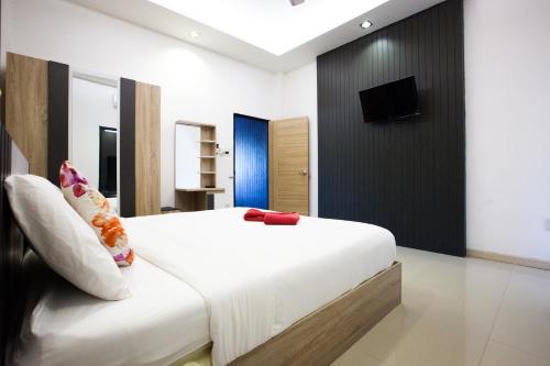1 dormitorio con 1 cama y TV en la pared en Blue Moon Design House, en Ko Samed