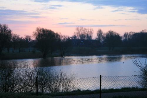 a view of a river at sunset at Hotel Seeblick garni in Gartow