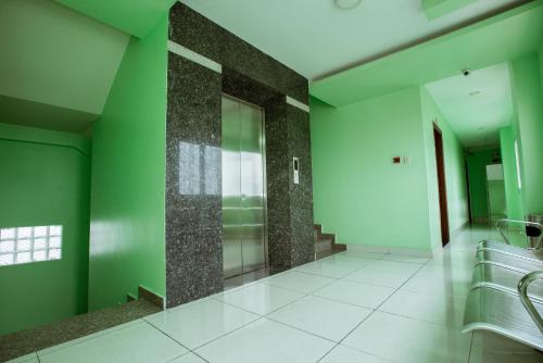 a bathroom with green walls and white tile floors at Eden Hotel Sài gòn in Ho Chi Minh City