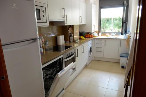 una cocina con electrodomésticos blancos y una ventana en Casa Alba, en Ribes de Freser