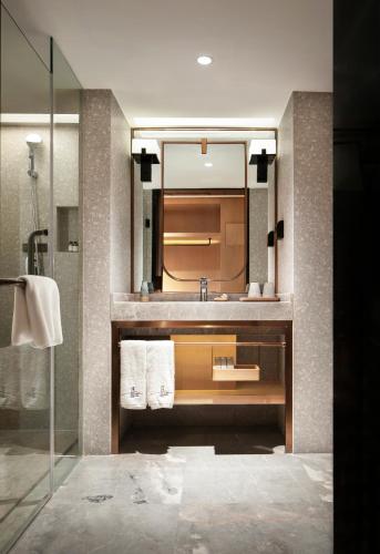 a bathroom with a sink and a mirror at Haikou S-INN Hotel in Haikou