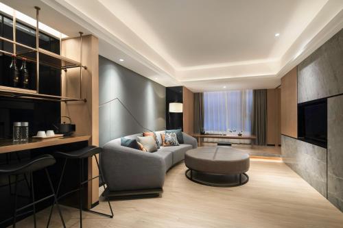 a living room with a couch and a table at Haikou S-INN Hotel in Haikou
