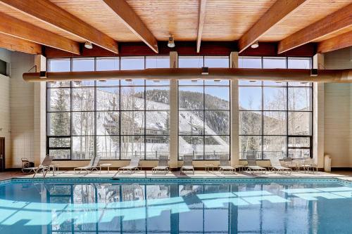 een groot zwembad met stoelen en een groot raam bij 2072 The Pines Condo in Keystone