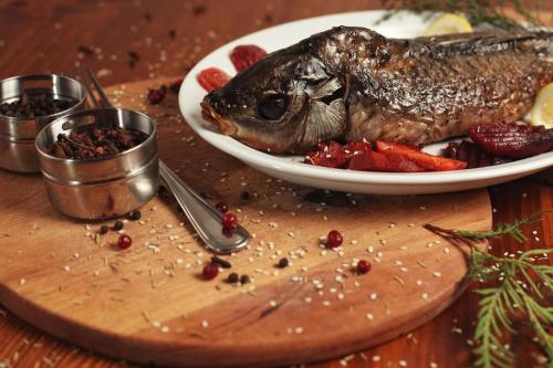 a fish on a plate on a wooden table at Georgiy in Oryavchyk