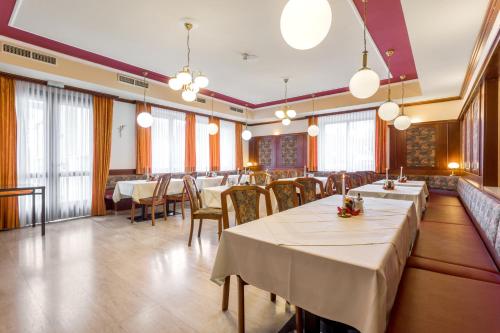 a dining room with tables and chairs and windows at Waldviertler-Hof in Langschlag