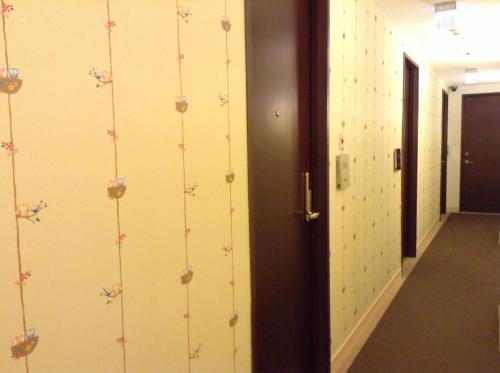 a hallway with a wall with flowers on it at Crystal Inn Sun Moon Lake in Yuchi