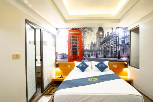 a bedroom with a red phone booth mural on the wall at Cozi 9 Hotel in Hai Phong