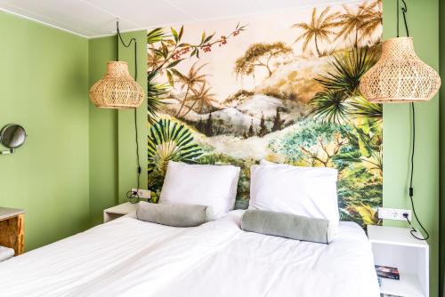 a bedroom with a bed with a painting on the wall at Boutique Hotel Charley's in Westkapelle