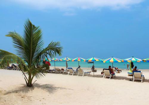 a group of people sitting in chairs on the beach at NaiYang beach Title Residencies by My Home Phuket in Nai Yang Beach