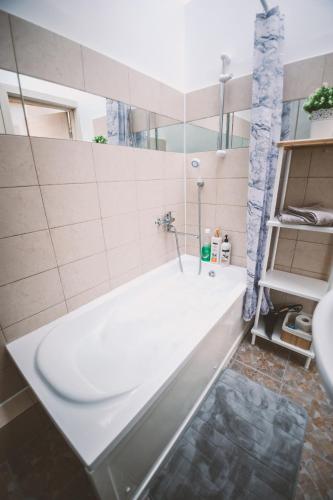 a bathroom with a tub and a sink at Apartamentai Niden - su terasa ir vaizdu i marias Nidos centre in Nida