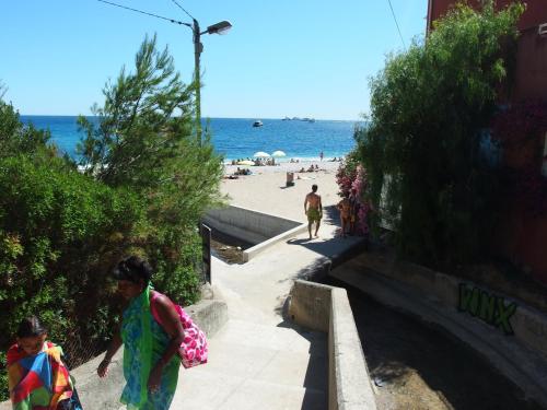 a group of people walking down the stairs to the beach at Résidence "Le Golfe Bleu" in Roquebrune-Cap-Martin