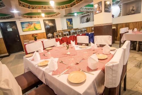 ein Esszimmer mit weißen Tischen und weißen Stühlen in der Unterkunft Central Hill Resort The Mall Road in Gangtok