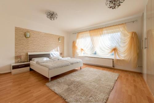 een slaapkamer met een bed en een groot raam bij Private Apartment in Ronnenberg