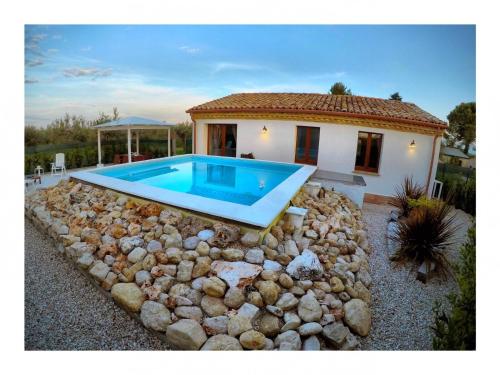 a pool in front of a house with rocks around it at Il Giardino Di Epicuro in Rocca San Giovanni