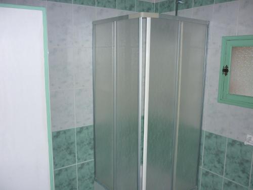 a shower with a glass door in a bathroom at Domaine De Rode Buze in Cahors