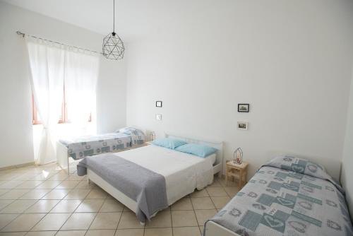 - une chambre avec 2 lits et une fenêtre dans l'établissement Villa Giusy, à Marina di Camerota