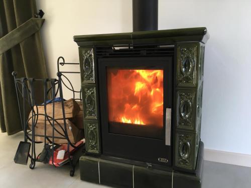 a stove with a fire in it in a room at Malinowe Wzgórze domki 90 m2 z sauną i balią in Krzeszna