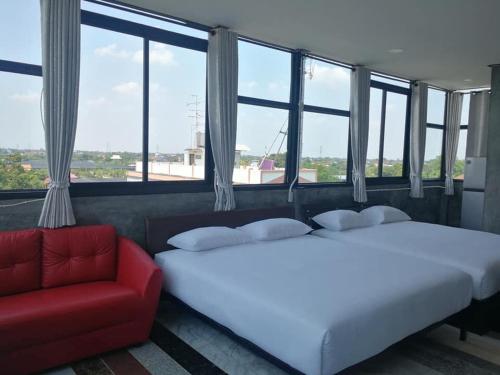 um quarto com 2 camas e um sofá vermelho em The loft residence em Banguecoque