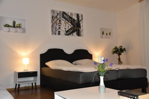 a bedroom with a bed and a table with a vase of flowers at Pension am Schloss in Schwerin