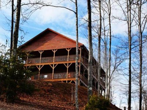 a large wooden house on a hill with trees at Spacious Party Hut Near Attractions in McCookville