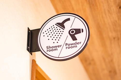 a mirror hanging on a wall with a shower powder room at I-Link Hostel & Cafe Shimanami in Imabari